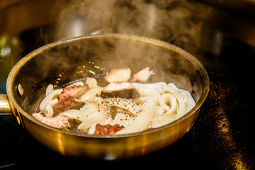 Shrimps and other seafood are fried in a pan