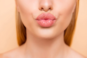 Air kiss for you. Close up cropped shot of femenine gorgeous charming adorable lady with nude natural full big pout lips isolated on beige background, perfection wellness wellbeing concept - obrazy, fototapety, plakaty