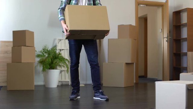 Student with sad face leaving dormitory taking box with his stuff, graduation