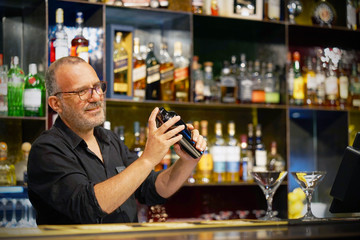  Elderly bartender holding a 