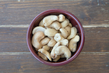 cashew nuts inside bowl on a wooden table viewed from above