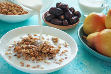 Traditional european breakfast. Milk and granola. Muesli, dates and fresh pears.