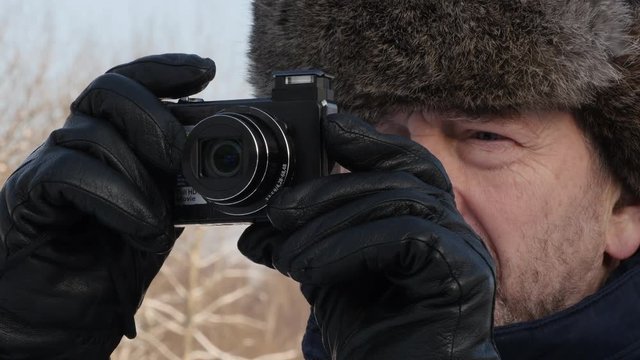 Elderly Bearded Man Taking Pictures With His Photo Camera On A Winter Day In The Forest