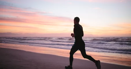 Foto auf Acrylglas Joggen Healthy man jogging along the sea shore