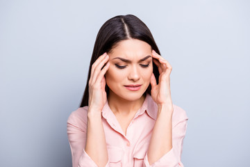 Portrait of upset, sad, unwell, unhealthy, disappointed woman feeling bad holding two hands on temples suffering from migraine isolated on grey background