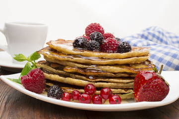 Delicious pancakes with berries and maple syrup. Top
