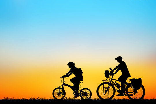 Silhouette love couple  and bike relaxing on sunset