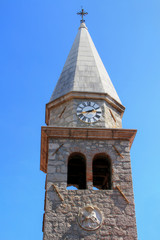 Clock tower of Church Crkva Svetog Jakova St James's Abbey in medieval core of Croatian resort town Opatija against the blue sky in a sunny summer day, Istrian peninsula Croatia Balkans Europe