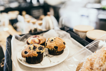 Homemade muffin chocolate on the wooden plate put on the wooden bar near coffee machine