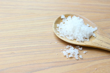 Sea salt on wooden ladle background