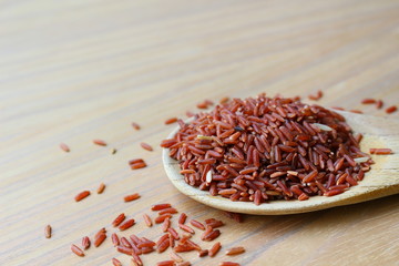 Brown rice on wooden ladle