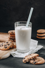 close-up shot of glass of milk with delicious chocolate-chip cookies