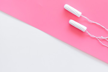 Woman hygiene protection. Cotton tampons on pink background top view copy space