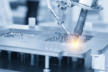 The soldering robot welding the circuit board in the light blue scene with the lighting effect.