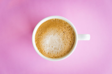 White cup of coffee on light pink  background