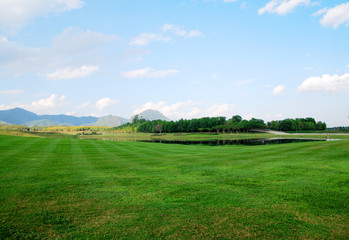 Landscape of Green grass field with cloud blue sky mountain background at singha parks and outdoor , chiang rai , thailand 