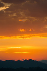 colorful dramatic sky with cloud at sunset. over silhouette mountains