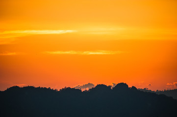colorful dramatic sky with cloud at sunset. over silhouette mountains