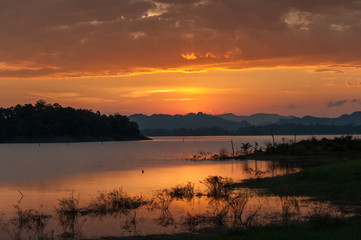 colorful dramatic sky with cloud at sunset. over silhouette mountains