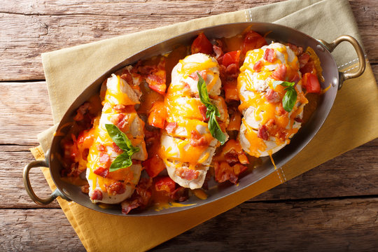 Chicken Breast Baked With Bacon, Tomatoes And Cheddar Cheese Close-up In A Frying Pan. Horizontal Top View From Above