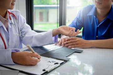 Patient sitting with Doctor for consulting at hospital office. Diagnostic, medical service, healthcare, consultation, healthy lifestyle or education concept