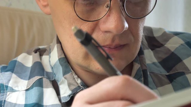 Close up, shot of a business man holding a pen, thinking and making notes in notebook during training.
