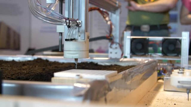 The production robots planting seeds in the soil at a modern technology exhibition and robotics in Russia.