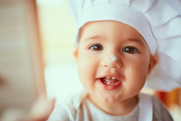 The small baby  playing with flour