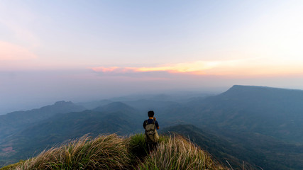 man traveller tourism photographer standing  on top of a cliff mountain during sunset - landscape sunset Thailand