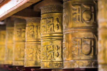 Tibetan buddhist praying wheels in Ladakh, India. Traditionally, the mantra Om Mani Padme Hum is written in Sanskrit on the outside of the wheel