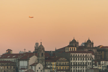 Fototapeta na wymiar Close-up view of historic city of Porto, Portugal with plane flying over during sunrise time