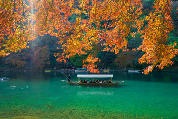 Obraz premium Pleasure boat at Arashiyama in Autumn season.