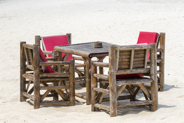 Fototapeta na wymiar Table and bamboo chairs in tropical beach next to the sea , Thailand. Close up