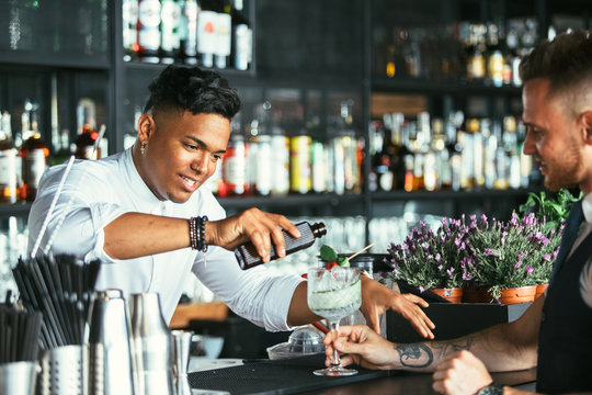 Bartender prepares a cocktail to a waiter