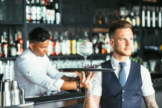 Elegant waiter serving a cocktail