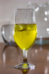 cloose up on yellow liquid in glass on table
