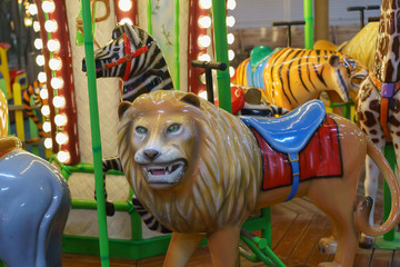 Fototapeta na wymiar Riding around a lion, zebra, tiger, elephant carousel 