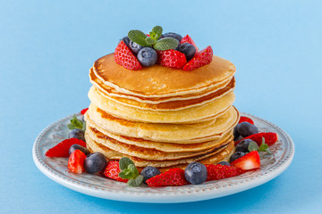 Pancakes with berries on a bright pastel background