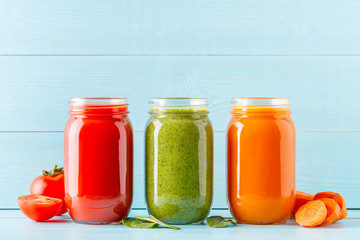 Orange/green/red colored smoothies / juice in a jar