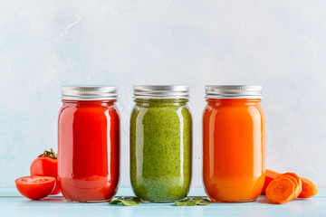 Orange/green/red colored smoothies / juice in a jar