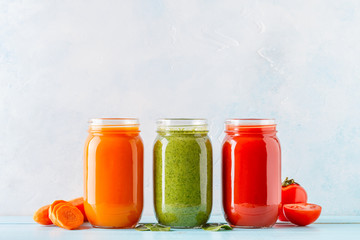 Orange/green/red colored smoothies / juice in a jar