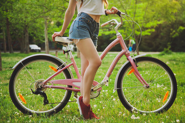 Fototapeta na wymiar Beautiful woman with bicycle in the park