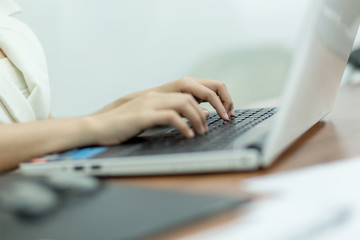 Selective focus Young business woman working on laptop in office.