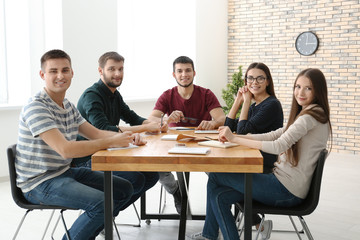 Group of young people sitting at table together, indoors. Unity concept