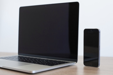 Laptop on wooden table notebook and phone