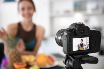 Female blogger with fruits on camera screen, closeup