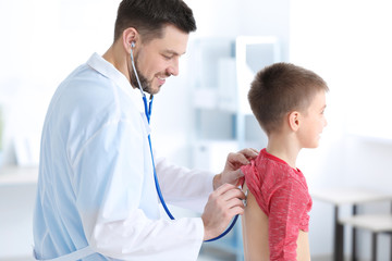 Children's doctor examining little boy in hospital