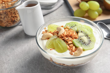 Bowl with yogurt, fruits and granola on table