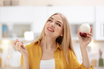 Young woman with yogurt on blurred background