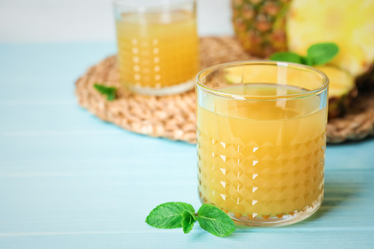 Glass with delicious pineapple juice on table